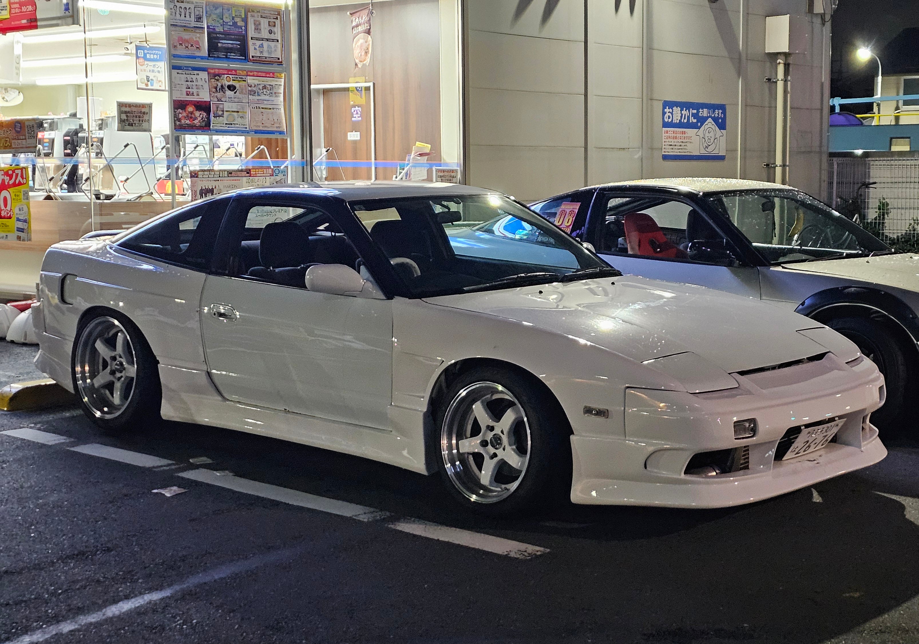 White 180sx sitting in front of Lawson in Japan